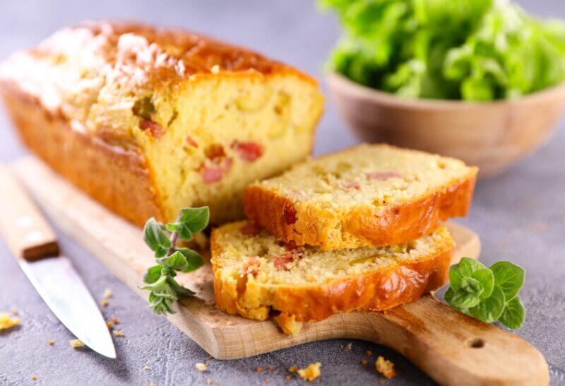 Cake salé doré garni de jambon et olives vertes, prêt à être dégusté