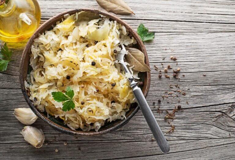 Plat de choucroute garnie alsacienne au mélange 5 baies, avec saucisses et viandes fumées, servi dans une cocotte.