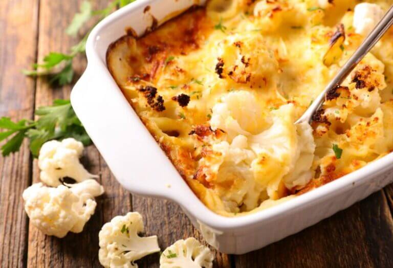 Plat de gratin de chou-fleur au mélange Colombo, doré et bouillonnant, servi dans un plat à gratin blanc.