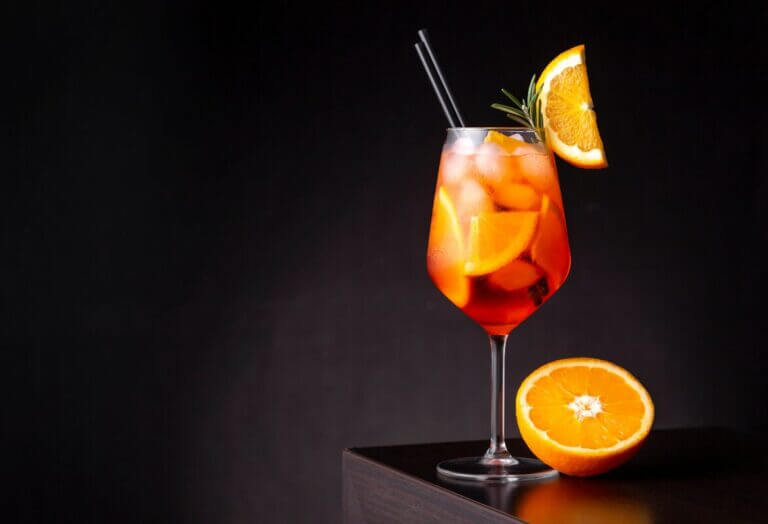 Verre de Spritz d'Hiver Épicé avec tranche de clémentine et bâton de cannelle
