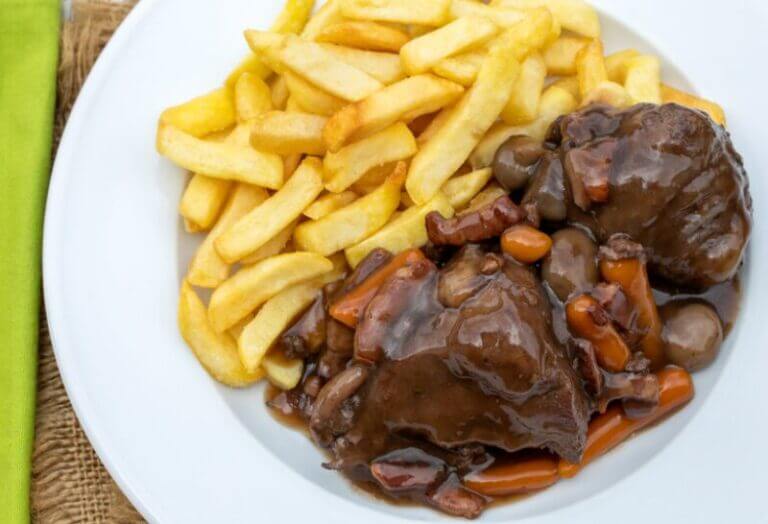 Coq au vin mijoté avec vin rouge, lardons et légumes, relevé au Poivre de Kampot