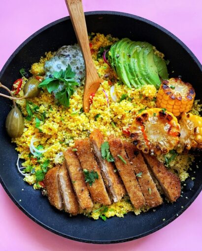 fried meat with green vegetable on black plate